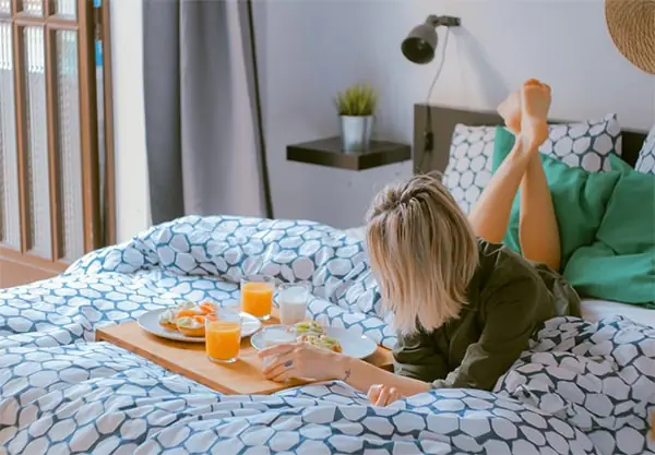 Breakfast tray on the bed with juice and pastries