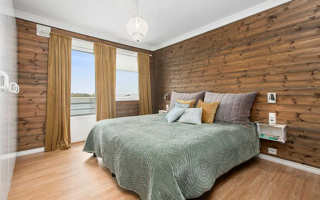 Fell Room: king bed with sage throw against oak-panelled wall