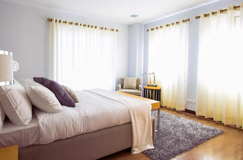 Linen Room: white bed in a bright room with sheer curtains
