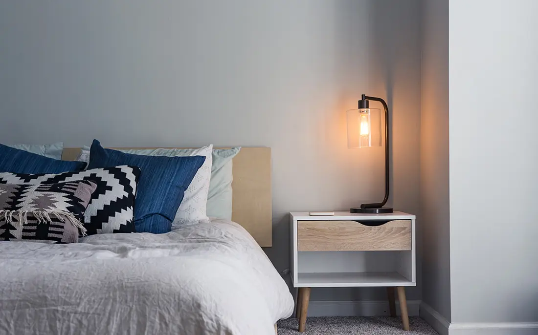 The Snug: double bed with navy cushions and a bedside lamp