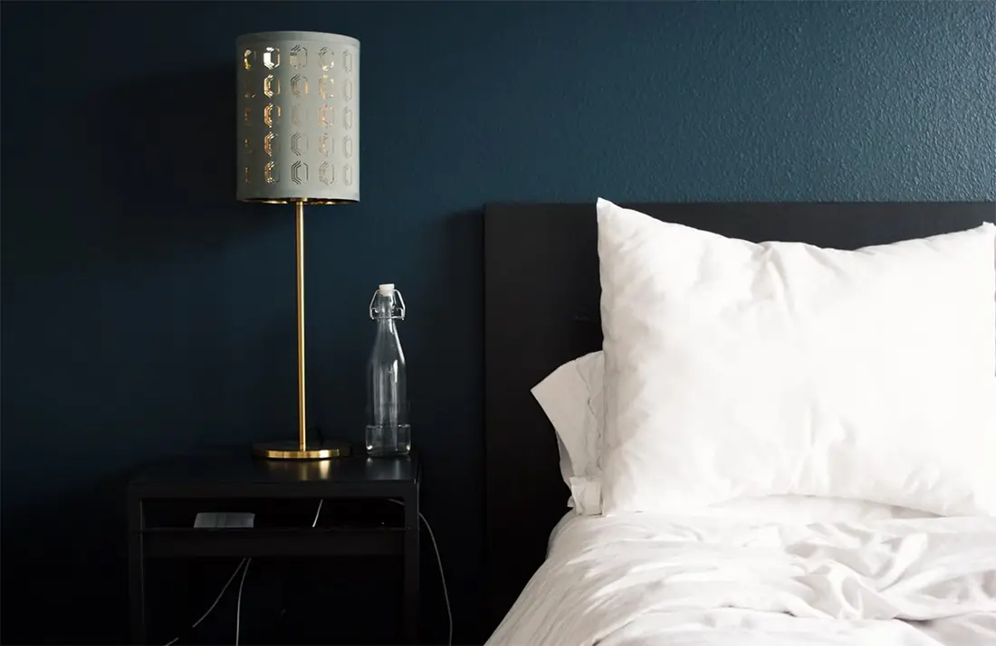 The Snug: brass bedside lamp against a deep blue wall